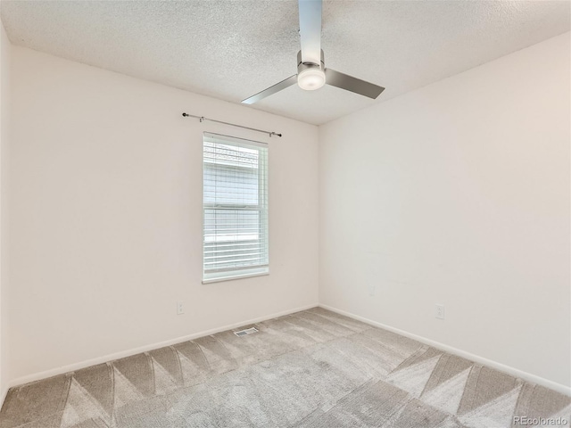 unfurnished room with a textured ceiling, light carpet, and ceiling fan