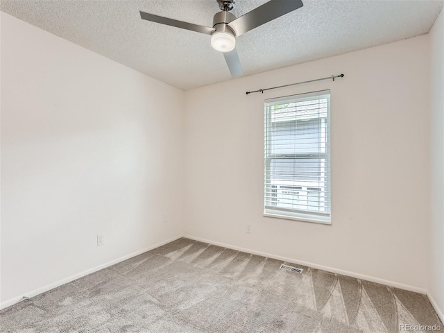 unfurnished room featuring a textured ceiling, carpet flooring, and ceiling fan