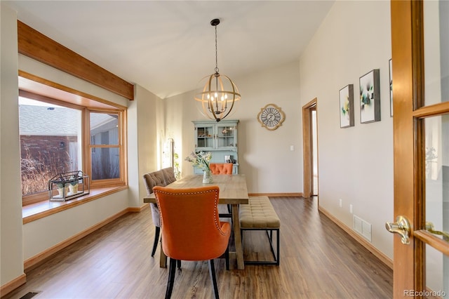 dining area with an inviting chandelier, wood finished floors, visible vents, and baseboards