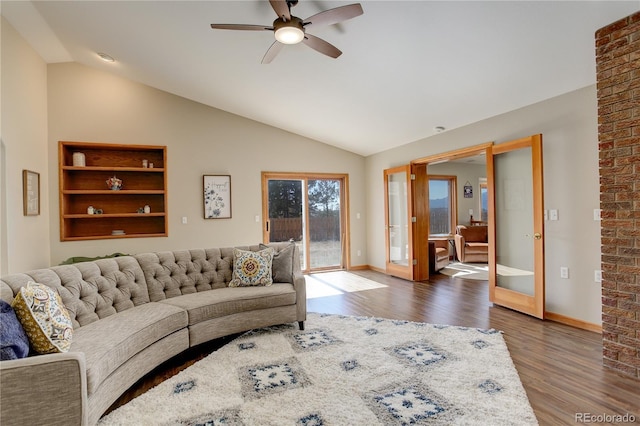 living area with baseboards, vaulted ceiling, french doors, wood finished floors, and a ceiling fan