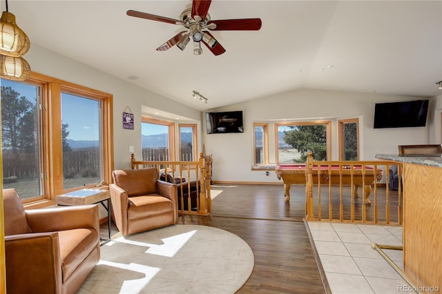 living room with plenty of natural light, wood finished floors, ceiling fan, and vaulted ceiling