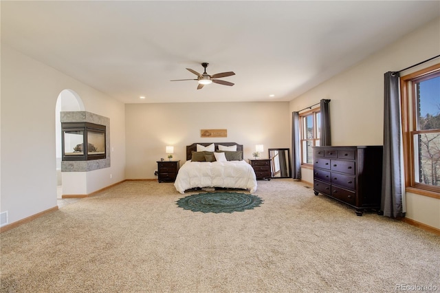 carpeted bedroom with visible vents, ceiling fan, baseboards, a tiled fireplace, and recessed lighting