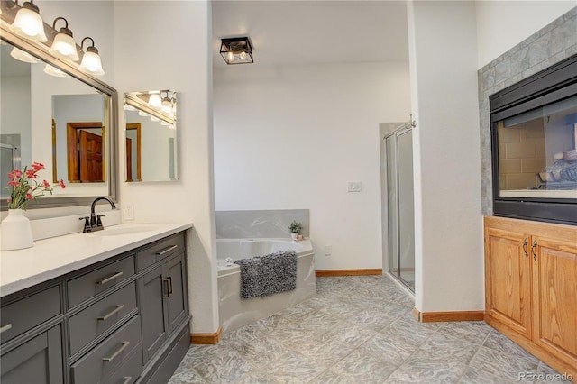 full bathroom with baseboards, a garden tub, a shower stall, and vanity