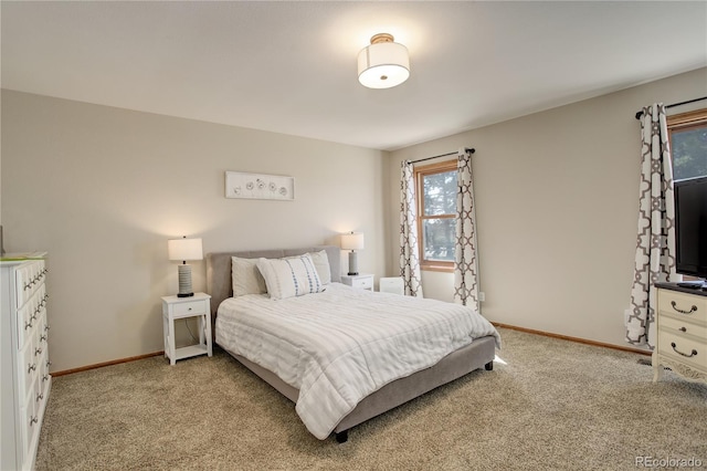 bedroom with baseboards and light carpet