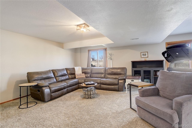 carpeted living room with visible vents, a textured ceiling, and baseboards