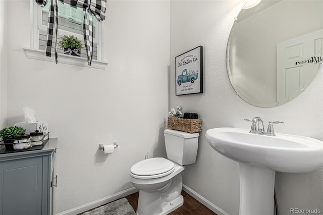 9350 Dunraven St, Arvada, CO 80007 - bathroom with wood finished floors, toilet, baseboards, and a sink