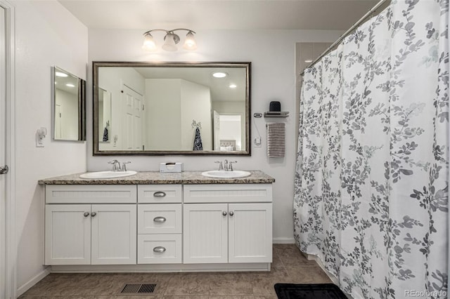 9350 Dunraven St, Arvada, CO 80007 - bathroom featuring double vanity, baseboards, tile patterned flooring, and a shower with shower curtain