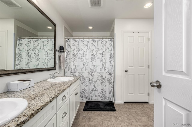 9350 Dunraven St, Arvada, CO 80007 - bathroom featuring double vanity, recessed lighting, a shower with shower curtain, and tile patterned flooring