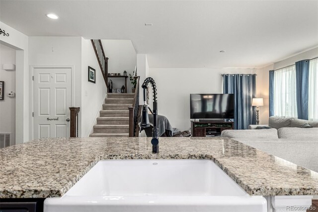 9350 Dunraven St, Arvada, CO 80007 - kitchen with open floor plan, light stone counters, and recessed lighting