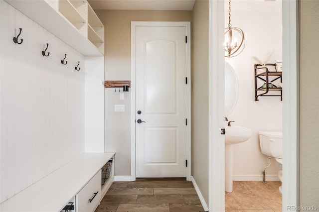 mudroom featuring wood-type flooring and a notable chandelier