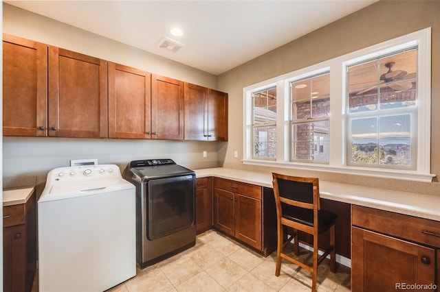 washroom featuring washer and clothes dryer, light tile patterned flooring, and cabinets