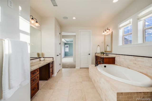 bathroom featuring vanity and a relaxing tiled tub