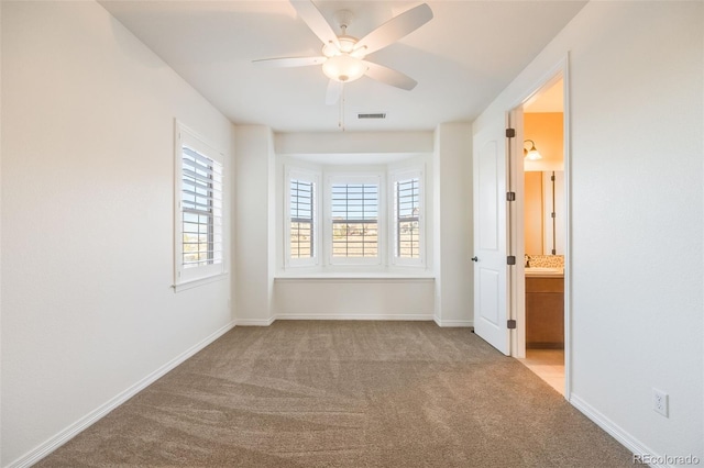 carpeted spare room with ceiling fan and sink