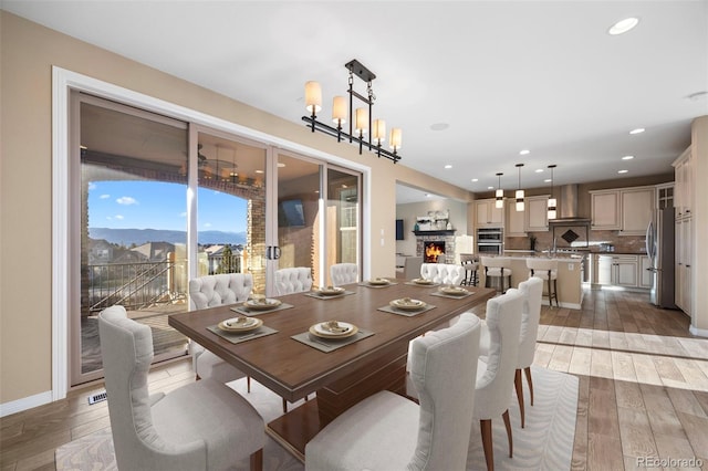 dining space featuring a mountain view, a fireplace, and an inviting chandelier