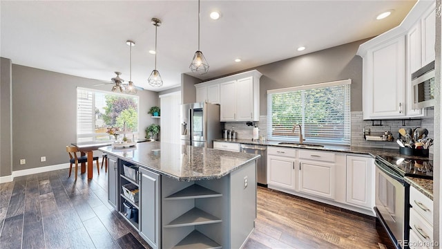 4826 S Ireland St, Aurora, CO 80015 - kitchen featuring stainless steel appliances, open shelves, a sink, white cabinets, and plenty of natural light