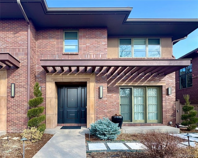 doorway to property with brick siding