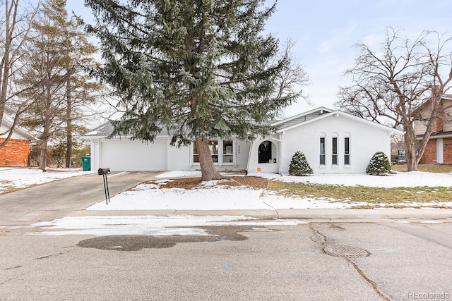 view of front facade featuring concrete driveway, an attached garage, and stucco siding