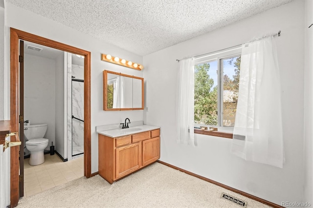 full bathroom featuring vanity, a textured ceiling, toilet, a shower with door, and baseboards