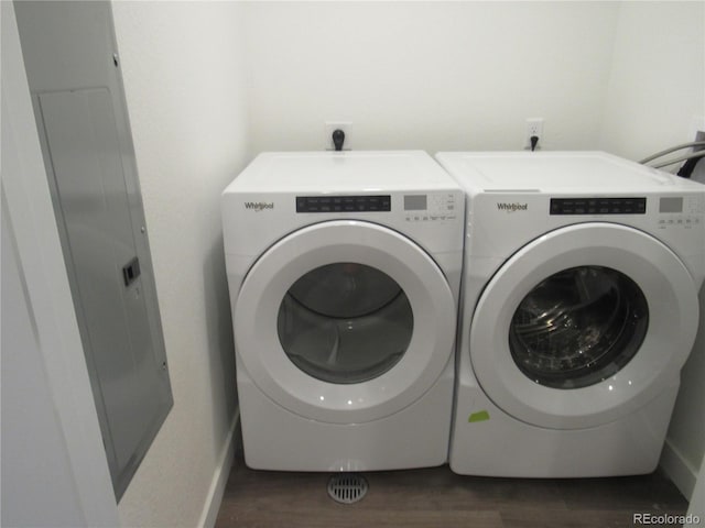 washroom featuring washing machine and dryer, laundry area, baseboards, and wood finished floors