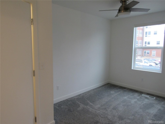 carpeted empty room featuring a ceiling fan, visible vents, and baseboards