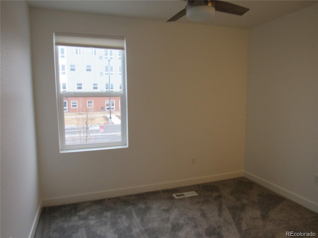 empty room with visible vents, carpet flooring, a ceiling fan, and baseboards