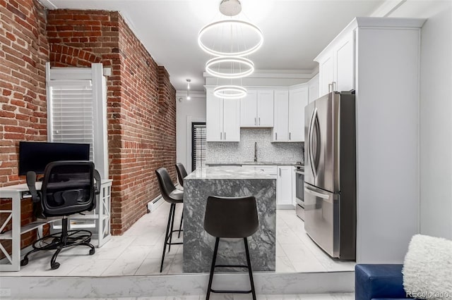 kitchen with a kitchen breakfast bar, appliances with stainless steel finishes, pendant lighting, white cabinets, and tasteful backsplash