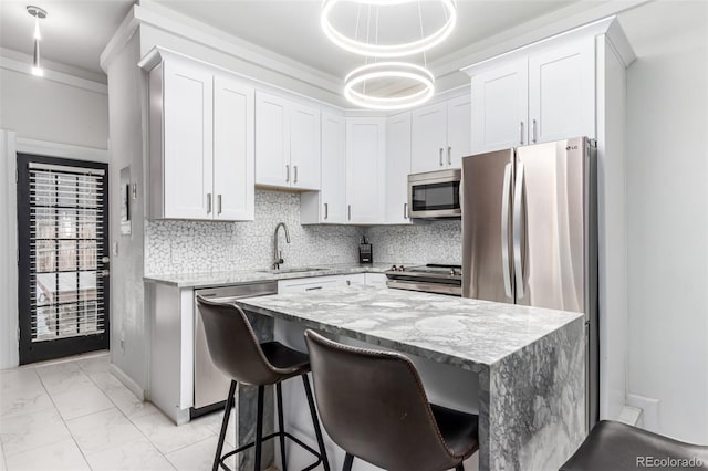 kitchen with stainless steel appliances, white cabinetry, hanging light fixtures, and light stone counters