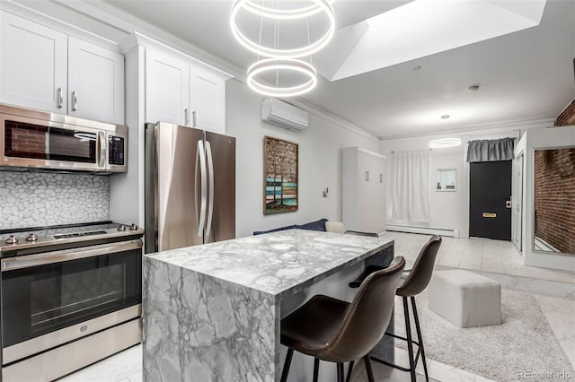 kitchen with stainless steel appliances, a wall mounted AC, a center island, white cabinets, and backsplash