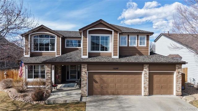 view of front of home with roof with shingles, driveway, brick siding, and fence