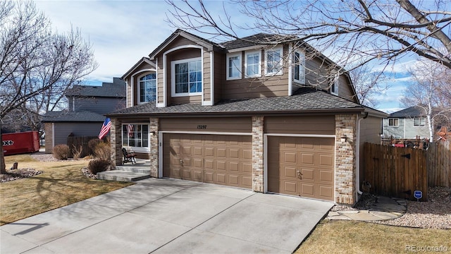 traditional-style home featuring a garage, fence, and driveway