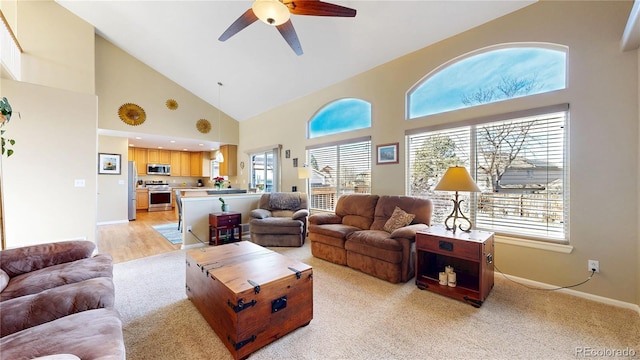 living area with high vaulted ceiling, plenty of natural light, baseboards, and a ceiling fan