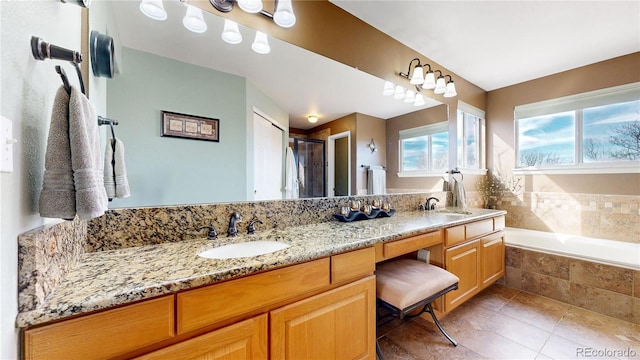 full bathroom featuring a garden tub, double vanity, tile patterned flooring, and a sink