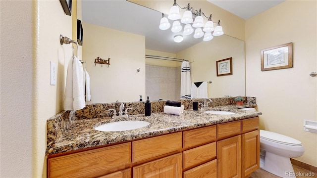 bathroom with double vanity, a shower with curtain, toilet, and a sink