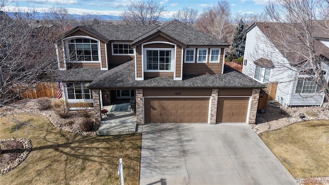 view of front of property with an attached garage, fence, driveway, roof with shingles, and a front yard