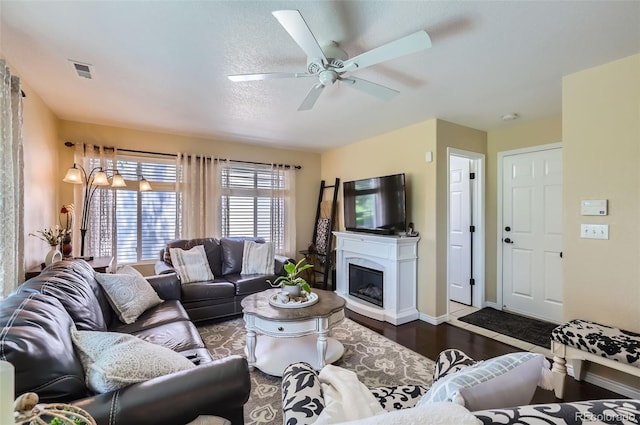 1201 Trout Creek Cir, Longmont, CO 80504 - living room featuring dark wood-style floors, a ceiling fan, and a glass covered fireplace
