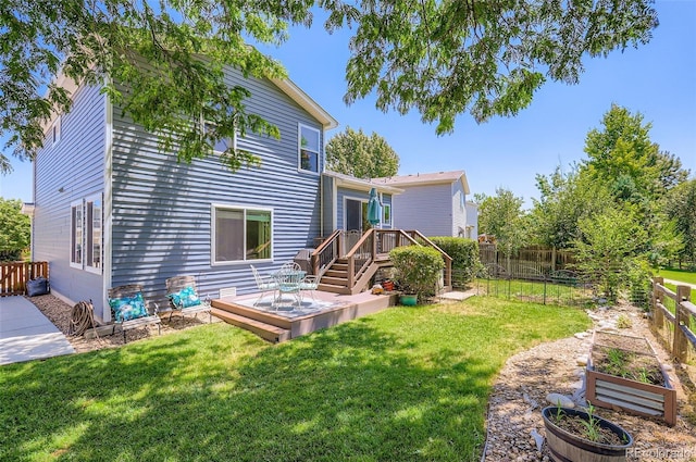 1201 Trout Creek Cir, Longmont, CO 80504 - rear view of property with a wooden deck, a fenced backyard, and a vegetable garden