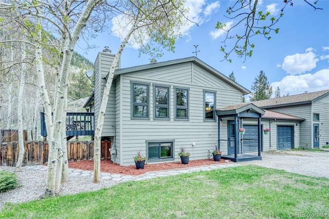140 Forest Dr, Frisco, CO 80443 - split level home featuring a chimney, gravel driveway, and a garage