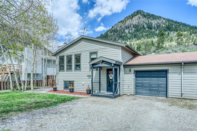 140 Forest Dr, Frisco, CO 80443 - split level home with gravel driveway, a mountain view, an attached garage, and a chimney