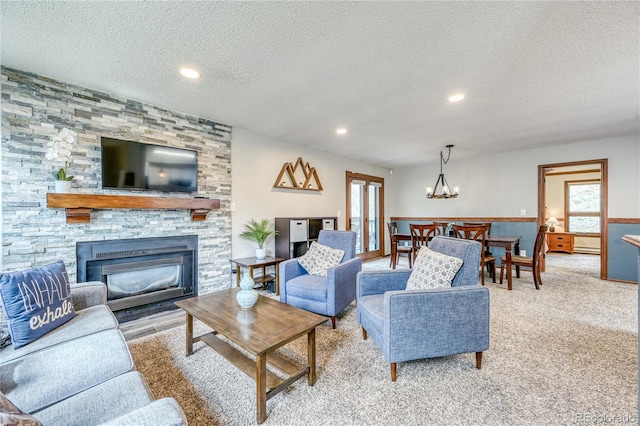 140 Forest Dr, Frisco, CO 80443 - living area featuring a textured ceiling, plenty of natural light, a chandelier, a fireplace, and carpet