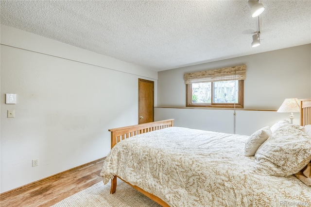 140 Forest Dr, Frisco, CO 80443 - bedroom with wood finished floors, rail lighting, and a textured ceiling