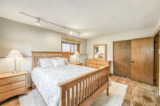 140 Forest Dr, Frisco, CO 80443 - bedroom with rail lighting, light wood finished floors, a closet, and a textured ceiling