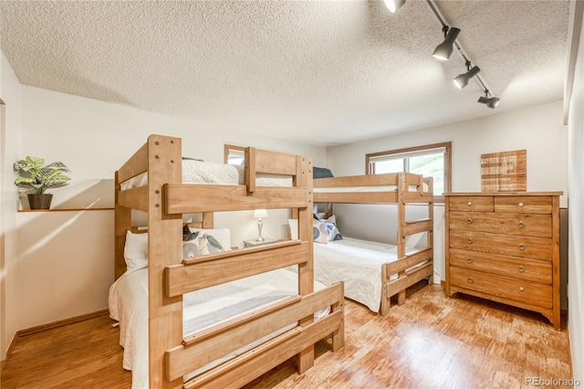 140 Forest Dr, Frisco, CO 80443 - bedroom with wood finished floors, a textured ceiling, rail lighting, and baseboards