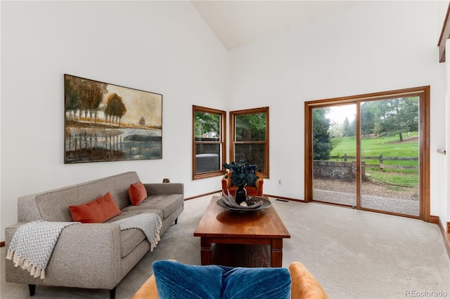 living area featuring light carpet, high vaulted ceiling, and baseboards