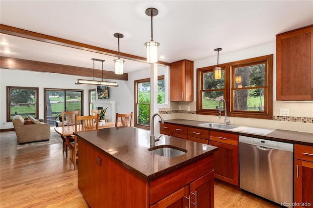 kitchen featuring stainless steel dishwasher, a sink, plenty of natural light, and beamed ceiling