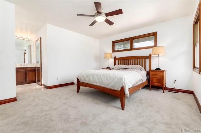 bedroom with light carpet, baseboards, connected bathroom, and ceiling fan