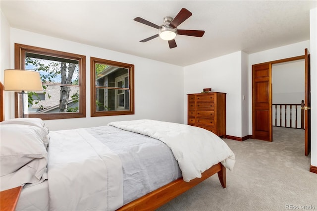 bedroom with light carpet, ceiling fan, and baseboards