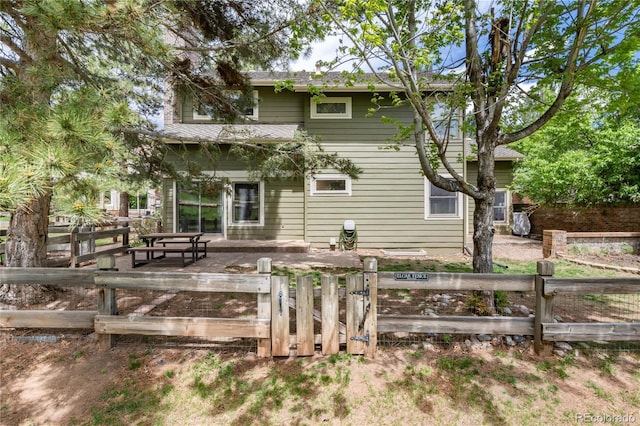 back of house featuring a patio area and a gate