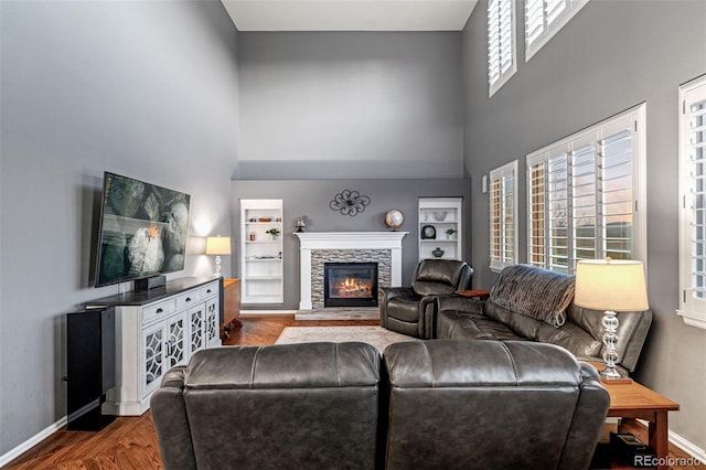 1609 S Catawba Cir, Aurora, CO 80018 - living room with a high ceiling, wood finished floors, a stone fireplace, and built in features