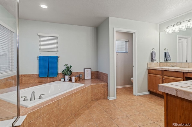 1609 S Catawba Cir, Aurora, CO 80018 - bathroom with vanity, a garden tub, tile patterned floors, and a textured ceiling