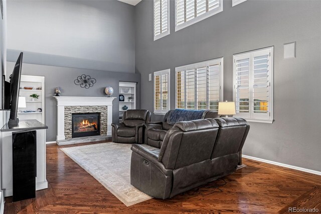 1609 S Catawba Cir, Aurora, CO 80018 - living area with a towering ceiling, a stone fireplace, dark wood finished floors, and built in features